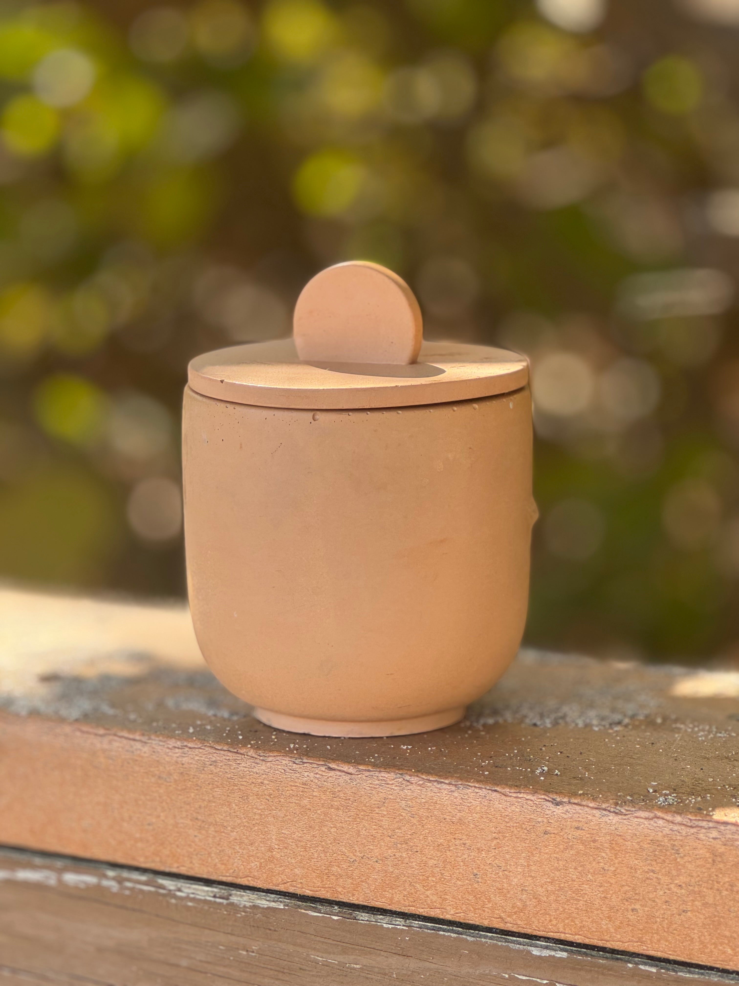 Coconut Glow Candle Co Champagne Toast concrete candle with lid, featuring a terracotta-like finish and a subtle round knob.